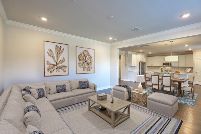 living room with light wood-style flooring, recessed lighting, visible vents, baseboards, and ornamental molding