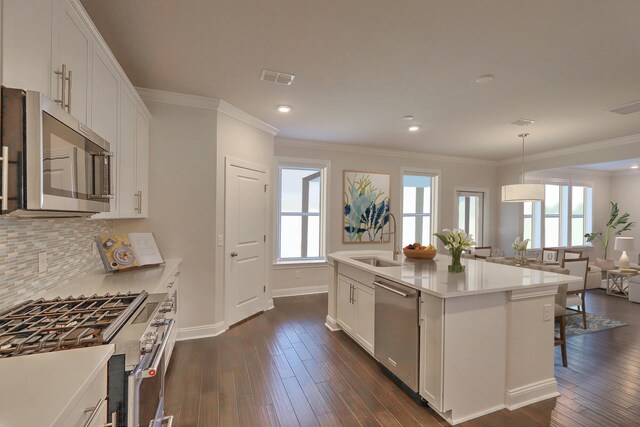 kitchen featuring a sink, visible vents, appliances with stainless steel finishes, backsplash, and dark wood-style floors