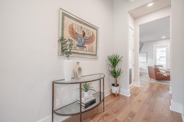 hall with baseboards, wood finished floors, and recessed lighting