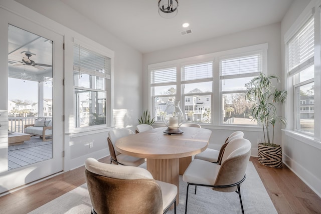 dining room with a healthy amount of sunlight, light wood finished floors, baseboards, and ceiling fan