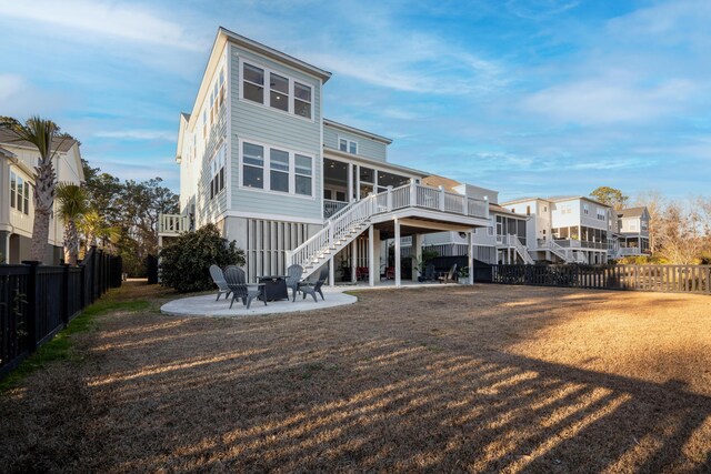 back of property featuring stairway, a fenced backyard, a patio area, a fire pit, and a deck