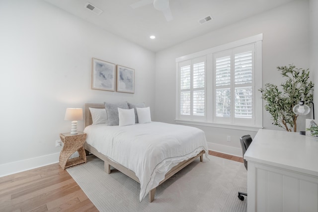 bedroom with light wood-style floors, visible vents, and baseboards