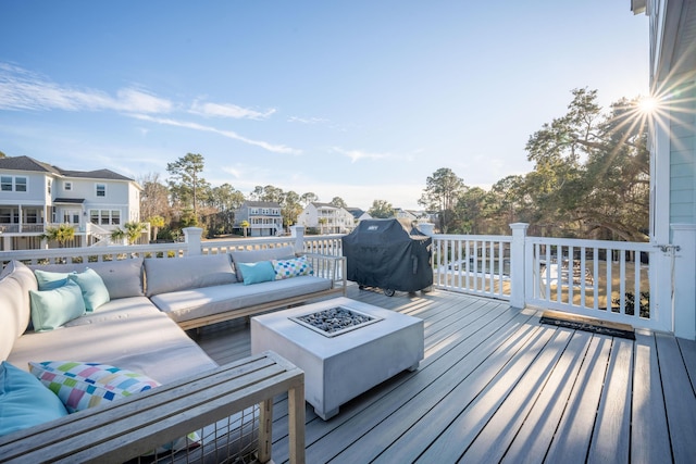 wooden terrace with a residential view, an outdoor living space with a fire pit, and area for grilling