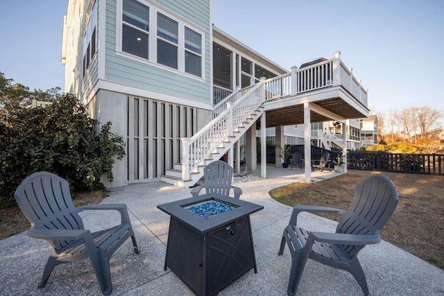 view of patio with a ceiling fan, stairs, a deck, a sunroom, and an outdoor fire pit