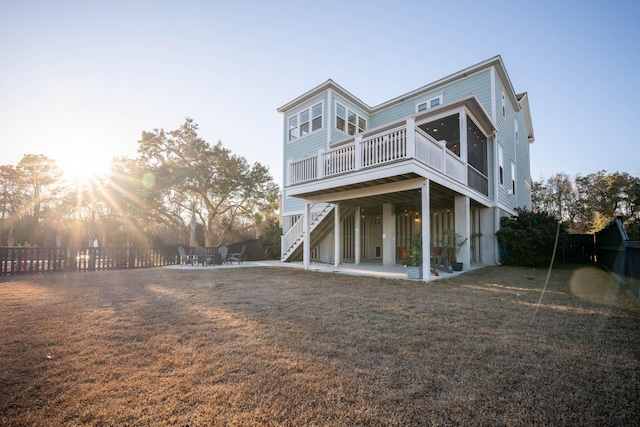 back of house featuring stairway, a fenced backyard, a yard, a wooden deck, and a patio