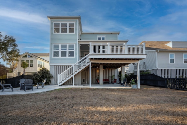 back of property with an outdoor fire pit, a deck, stairs, and a patio