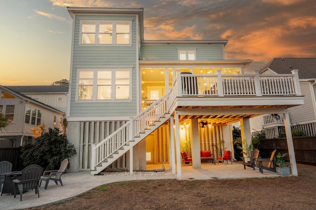 rear view of property featuring stairway, a wooden deck, fence, and a patio
