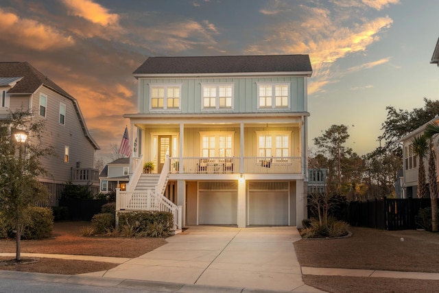 coastal inspired home featuring stairway, board and batten siding, driveway, covered porch, and a garage