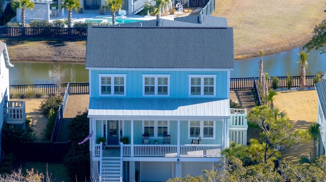 exterior space featuring fence, a water view, and stairs