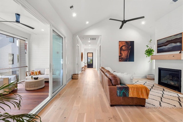 living area with a fireplace, light wood-style floors, and visible vents