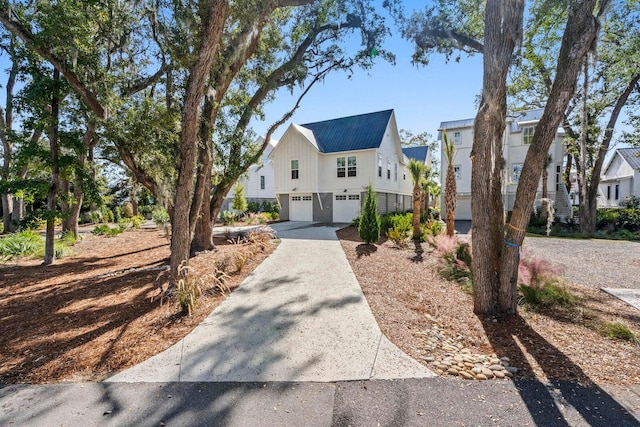 view of front facade with driveway, metal roof, and a garage