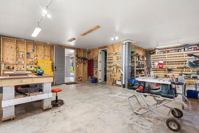 garage with a workshop area and wood walls