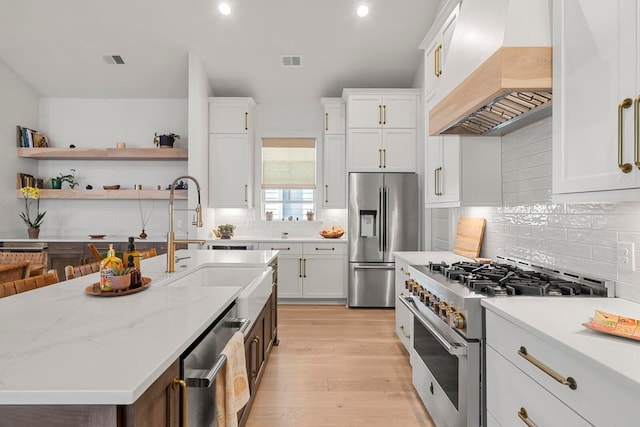 kitchen featuring visible vents, white cabinets, stainless steel appliances, and custom range hood