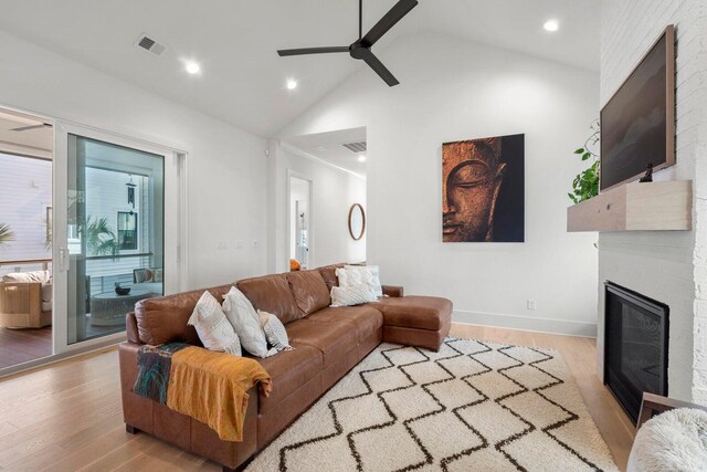 living room with visible vents, a fireplace, ceiling fan, and wood finished floors