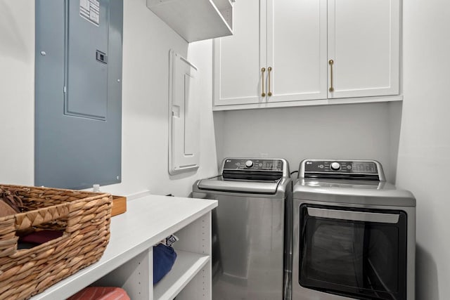 laundry room featuring washer and dryer, electric panel, and cabinet space