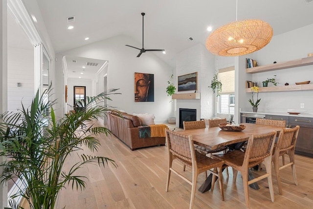 dining space with visible vents, a healthy amount of sunlight, a fireplace, and light wood-style floors