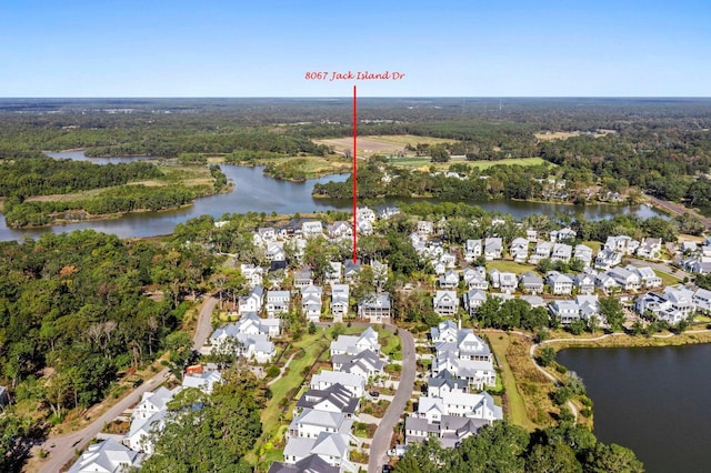 drone / aerial view with a forest view, a residential view, and a water view