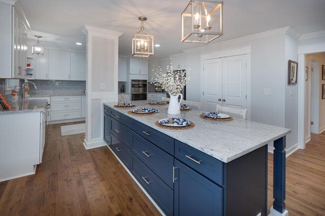 kitchen with blue cabinets, white cabinets, ornamental molding, and decorative backsplash