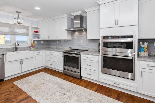 kitchen featuring dark wood finished floors, wall chimney exhaust hood, appliances with stainless steel finishes, open shelves, and a sink