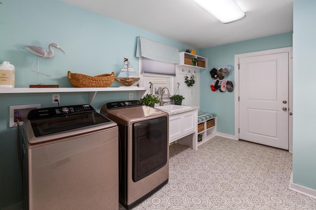 laundry area featuring laundry area, washer and clothes dryer, a sink, and baseboards