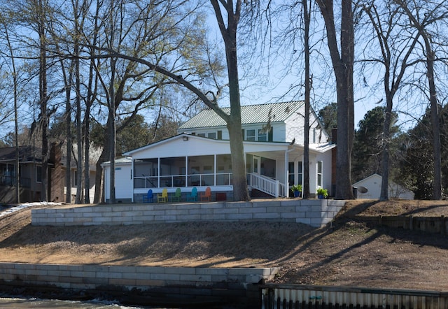 back of house with a sunroom and metal roof