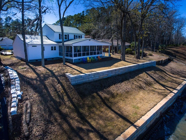 rear view of house with metal roof, crawl space, and a sunroom