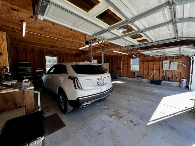 garage with a garage door opener and electric panel