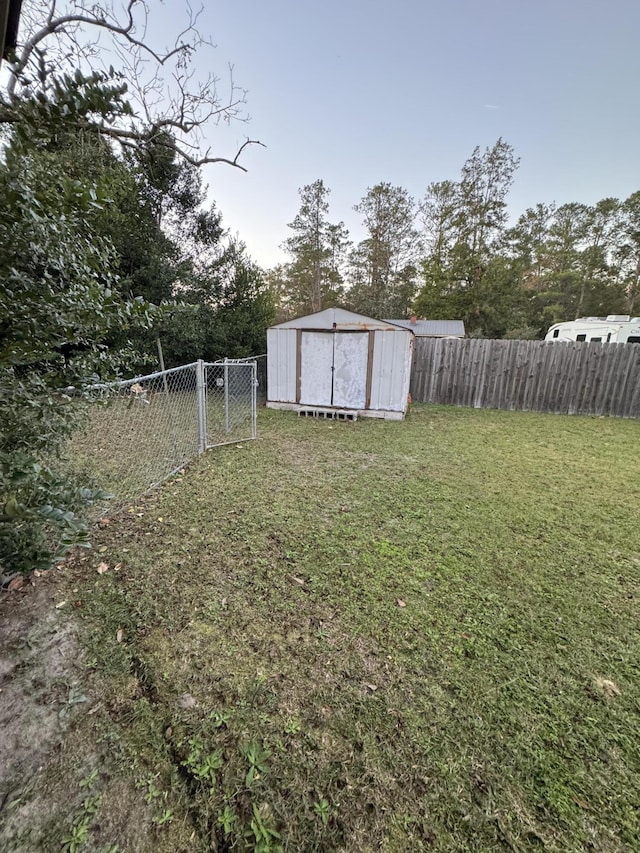 view of yard with an outdoor structure, a shed, and a fenced backyard