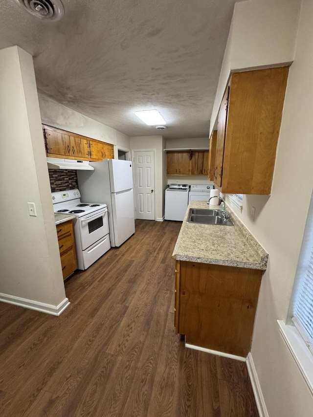 kitchen with a sink, under cabinet range hood, white appliances, brown cabinetry, and baseboards