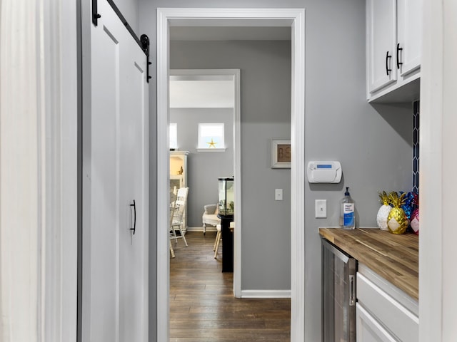 interior space with a barn door, dark hardwood / wood-style flooring, and wine cooler