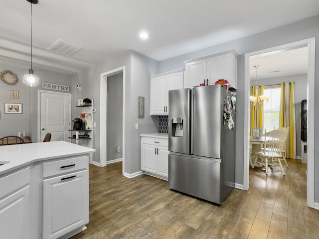 kitchen with a notable chandelier, white cabinetry, wood-type flooring, hanging light fixtures, and stainless steel fridge with ice dispenser