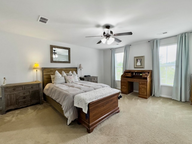 bedroom featuring multiple windows, ceiling fan, and light carpet