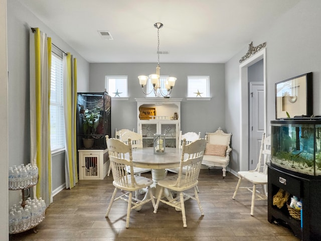 dining room with hardwood / wood-style floors and a chandelier