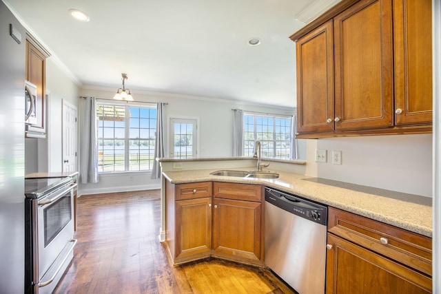 1713 Pimlico Blvd, Moncks Corner, SC 29461 - kitchen featuring stainless steel appliances, a sink, brown cabinets, ornamental molding, and a peninsula