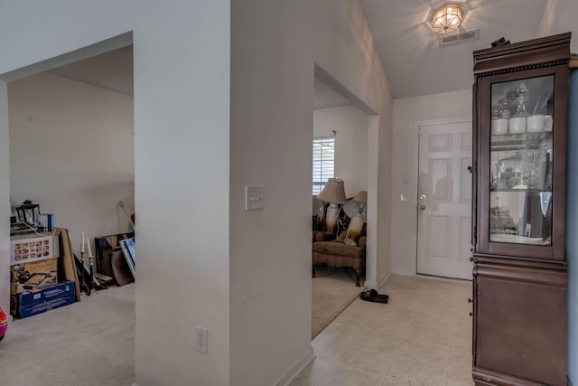 entrance foyer featuring baseboards, light tile patterned floors, and visible vents