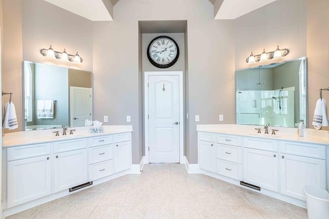 bathroom with a walk in shower, a sink, visible vents, and tile patterned floors