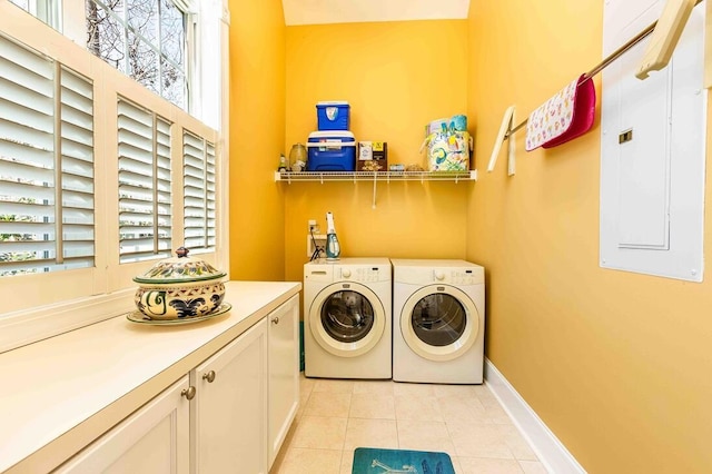 washroom featuring cabinet space, light tile patterned floors, electric panel, baseboards, and separate washer and dryer