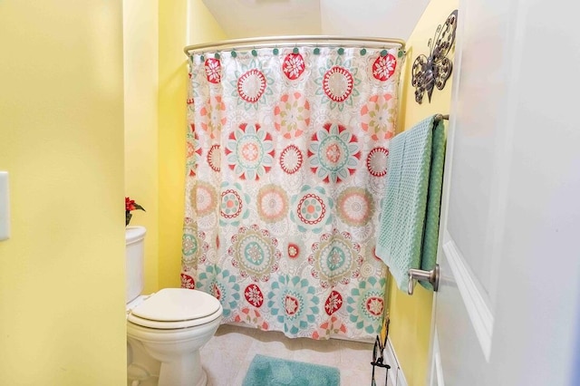 full bathroom featuring a shower with shower curtain, toilet, and tile patterned floors