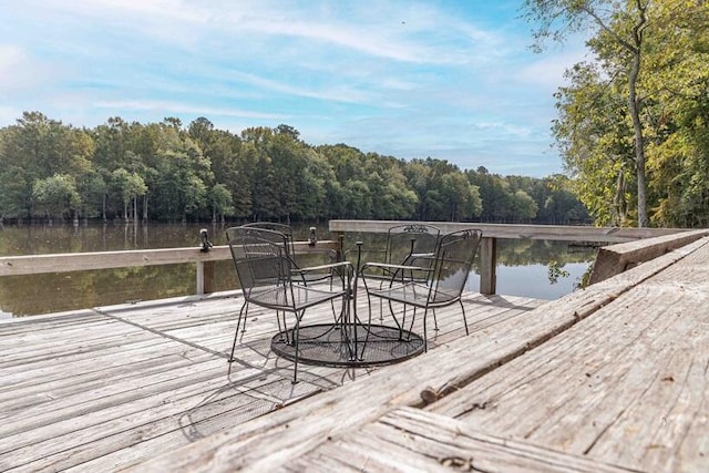 view of dock featuring a water view and a wooded view