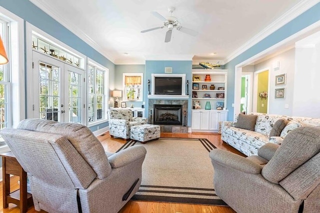 living area with french doors, a fireplace, plenty of natural light, and wood finished floors