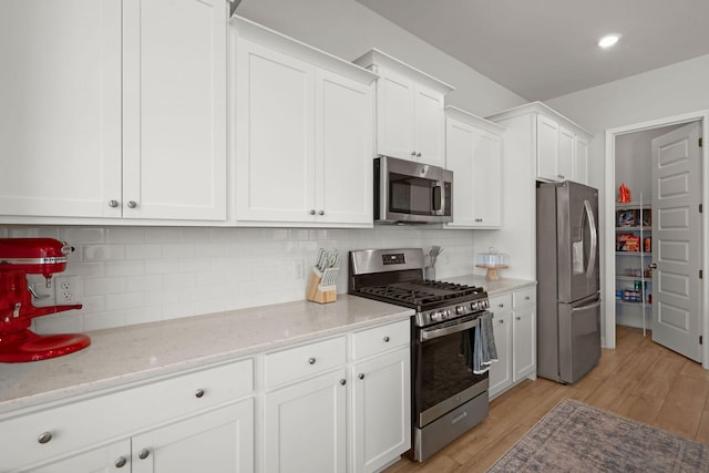 238 Bird Song Path, Summerville, SC 29485 - kitchen with appliances with stainless steel finishes, white cabinetry, tasteful backsplash, and light stone counters