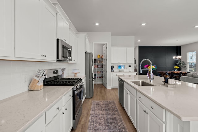 238 Bird Song Path, Summerville, SC 29485 - kitchen featuring stainless steel appliances, a sink, light wood-style flooring, a kitchen island with sink, and white cabinets