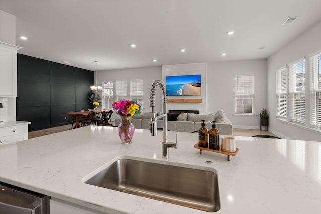 238 Bird Song Path, Summerville, SC 29485 - kitchen with a sink, light stone counters, recessed lighting, open floor plan, and white cabinetry