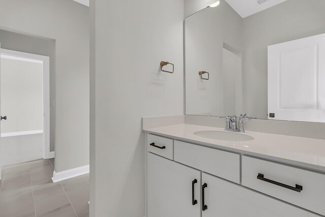 bathroom featuring tile patterned flooring, visible vents, vanity, and baseboards