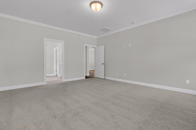 carpeted spare room with visible vents, baseboards, and crown molding