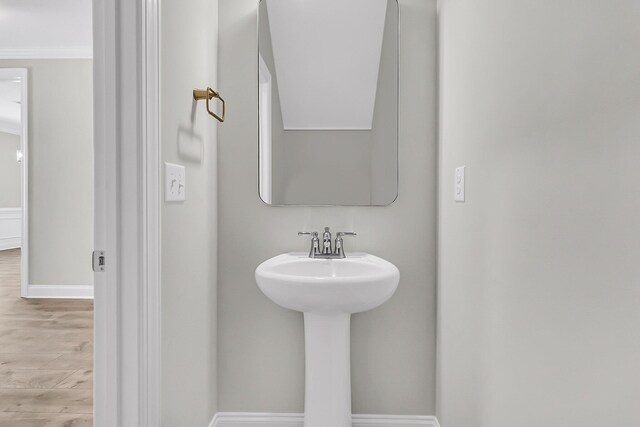 bathroom with a sink, wood finished floors, and baseboards