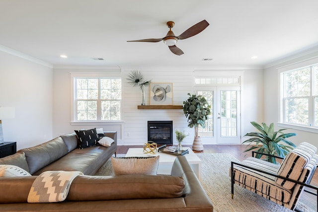 living area featuring ornamental molding, wood finished floors, and visible vents