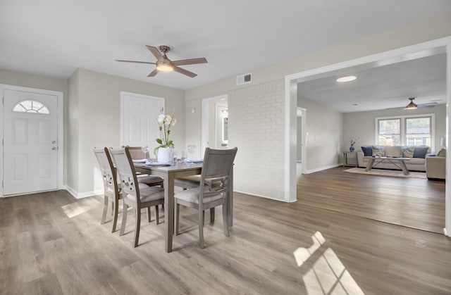 dining area featuring wood finished floors, visible vents, and baseboards