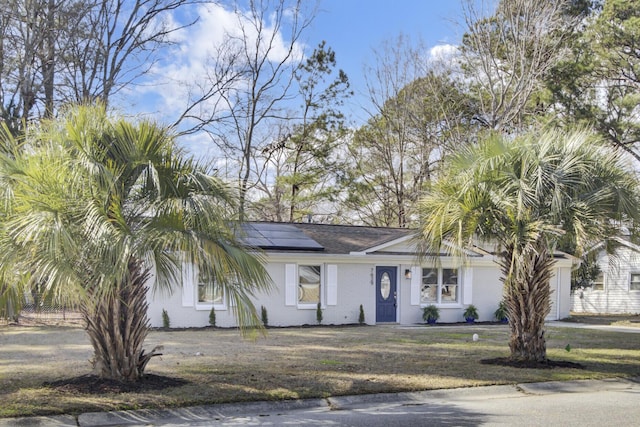 view of front facade with solar panels and an attached garage