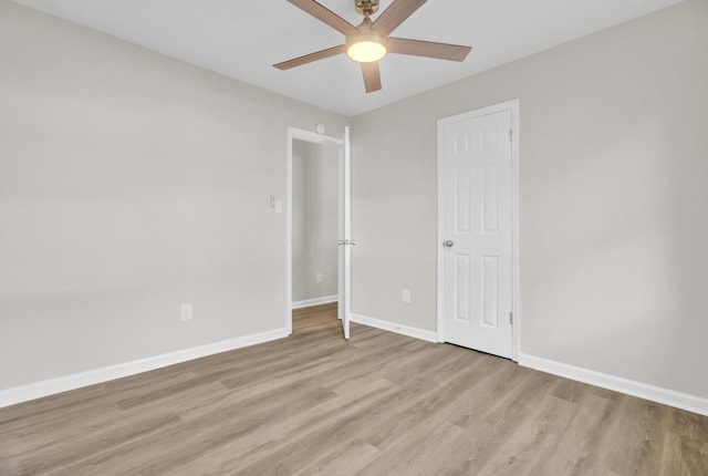 empty room featuring ceiling fan, light wood-style flooring, and baseboards